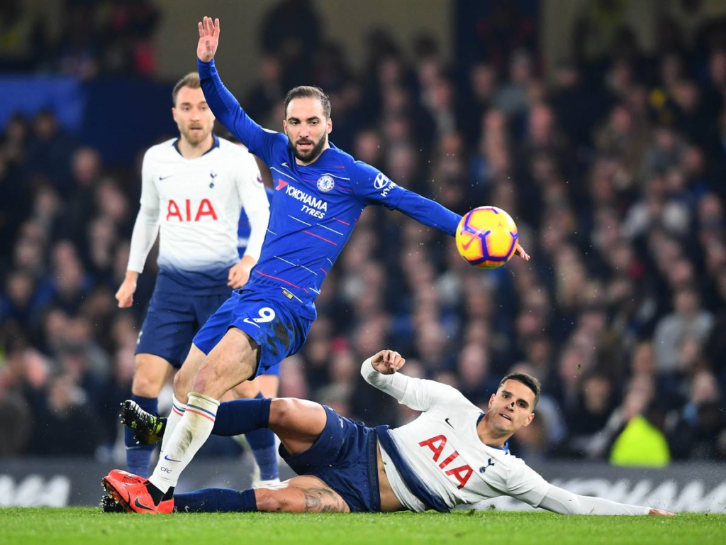 Gonzalo Higuain is challenged by Erik Lamela during the Premier League match at Stamford Bridge. Image: Getty Images