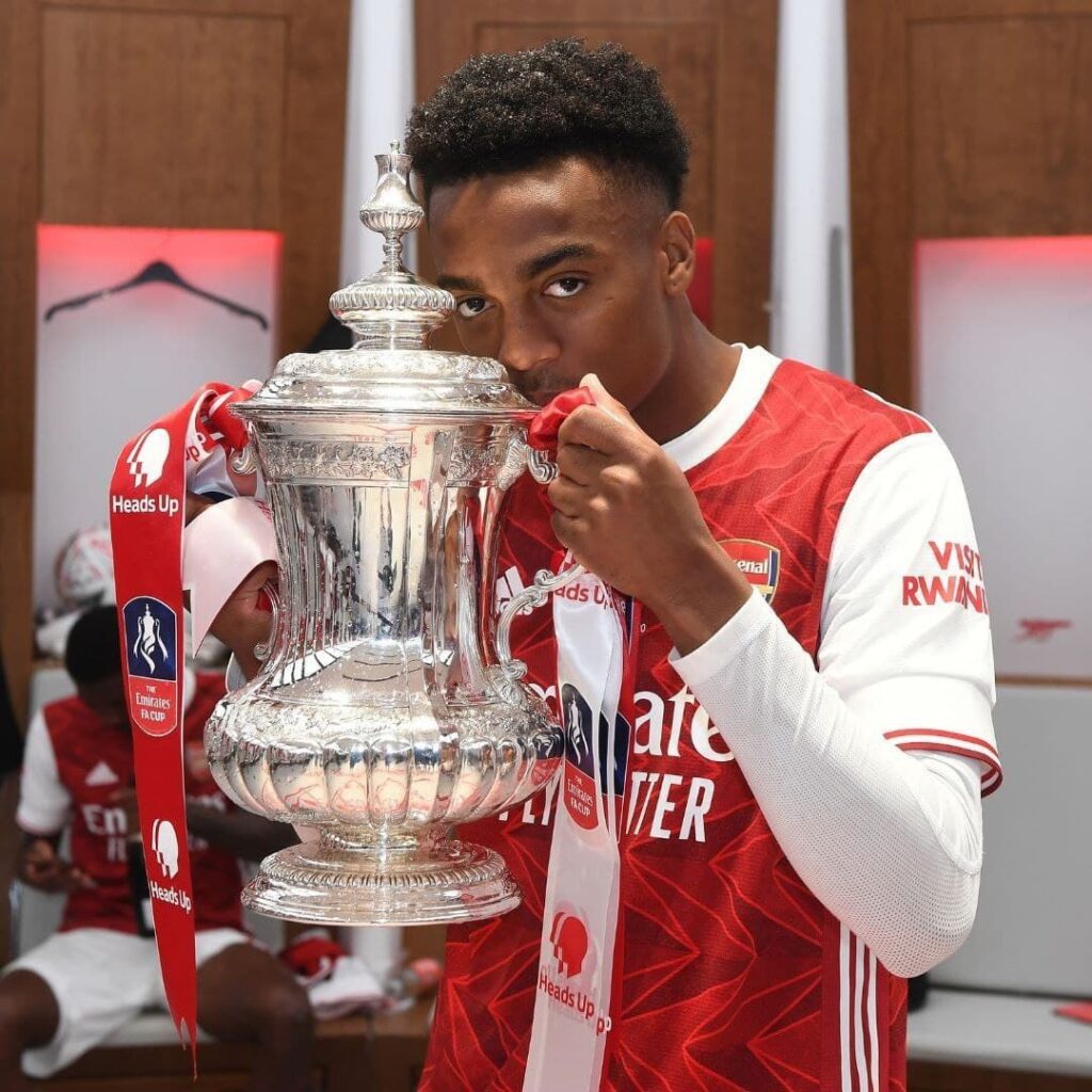 Joe Willock holding up the FA cup following their win in 2019-20 season. The player has been sold to Newcastle and therefore wont be available for the London derby